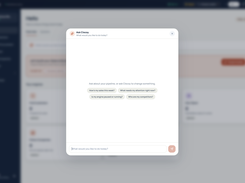 Clocsy interface with an Ask Clocsy assistant modal, suggested questions, a message field, and a blurred dashboard behind it.