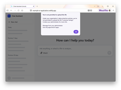 A browser-based mock chat assistant displays a dialog stating that an upload is blocked by organizational data-protection policies.