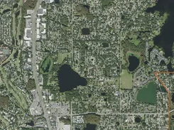Satellite view of a suburban area with lakes and a partial orange boundary line along the right side.
