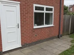 Mobile camera-recording interface over a view of a brick house wall, door, window, and patio, with recording timer, Stop, and Snapshot controls.